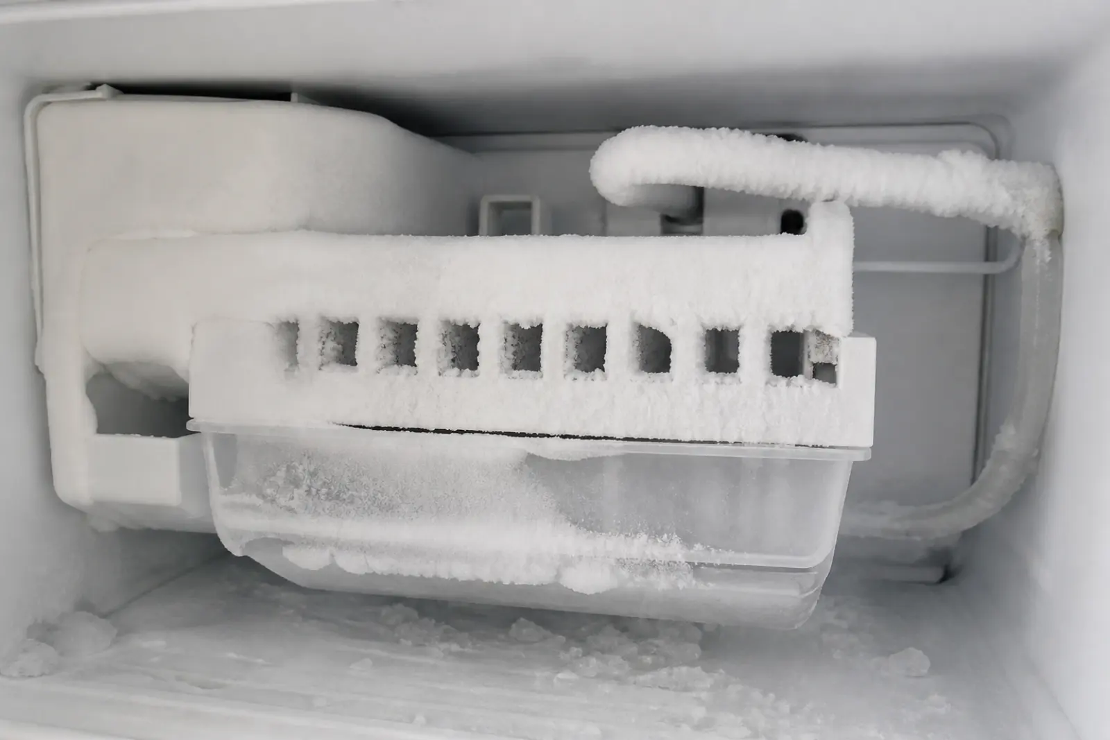 Frozen ice maker with frost buildup in a freezer
